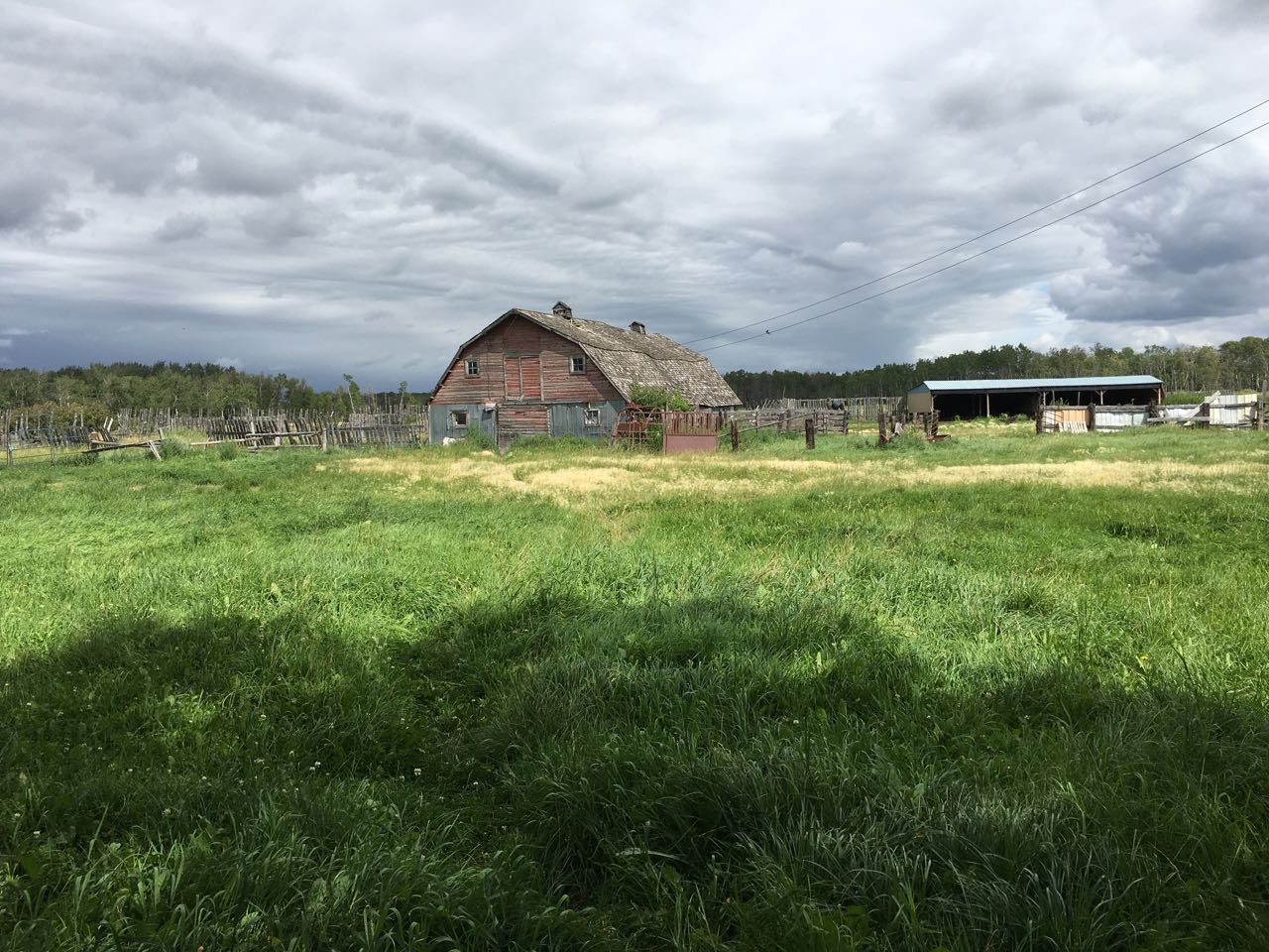 A weathered red barn beyond the meadow
